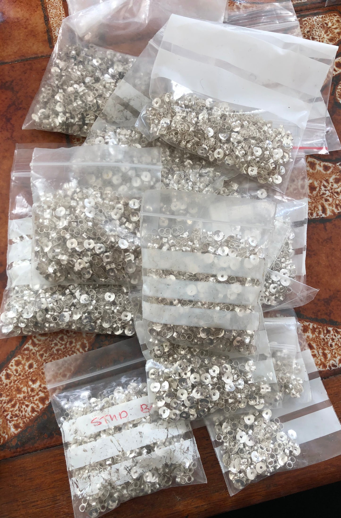 25 pairs (50 pierces in total) of silver coloured earring backs for studs